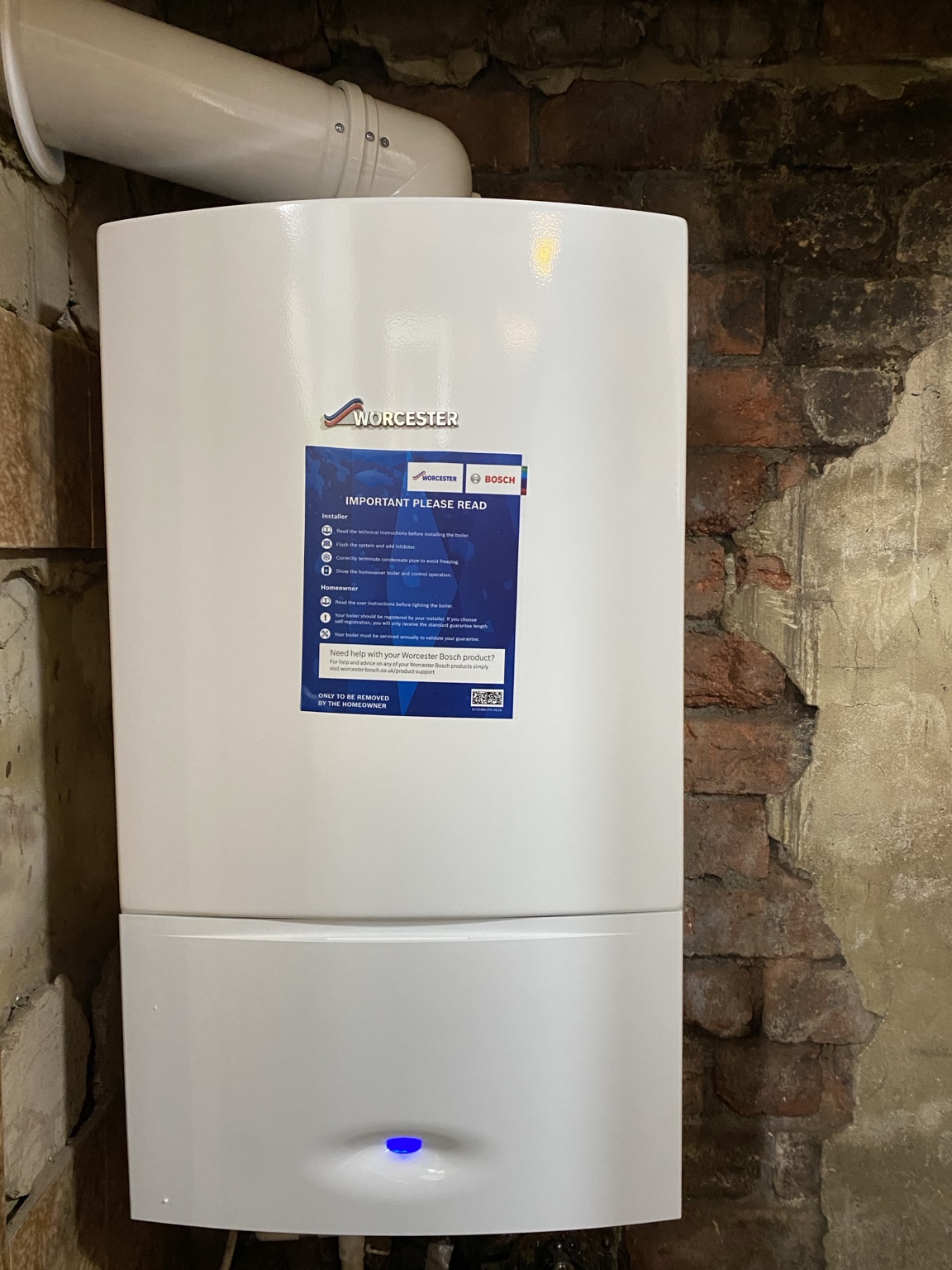 New Worcester Bosch boiler installation on a brick wall with a wall flue